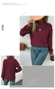 Detail view of burgundy knitted sweater with a chest pocket and ribbed cuffs