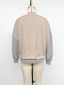 Back view of a loose color-block sweatshirt with gray ribbed cuffs and beige soft fabric