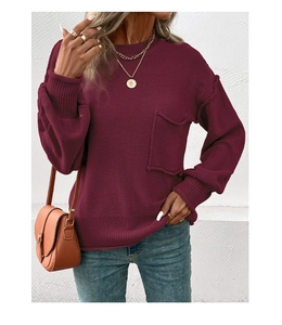 Detail shot of the ribbed cuffs and textured knit fabric on a burgundy sweater