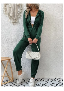 Detail of dark green hooded jumpsuit with drawstring waist and metal zipper closure