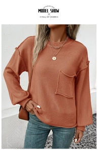 Detail of caramel knit sweater featuring decorative outer seams and a large chest pocket