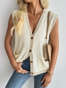 Detail of V-neck knit vest featuring contrast stripes and tortoise shell buttons