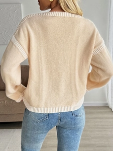 Back view of a beige V-neck knit cardigan with white ribbed trims and bow details