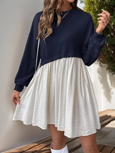 Detail of navy blue sweatshirt dress featuring white pleated skirt and ribbed cuffs