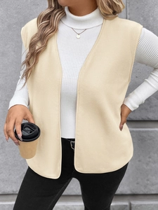 Detail of a minimalist beige fleece vest paired with a white turtleneck sweater