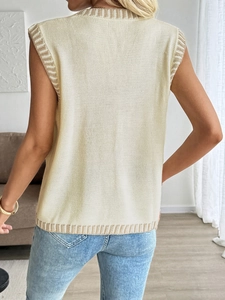 Detail view of the yellow knit sweater vest showing fine texture and ribbed hemlines