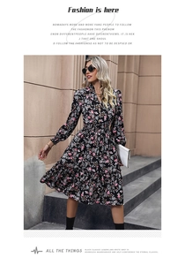 Close-up detail of French style floral dress featuring V-neck and ruffled layered skirt