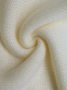 Macro shot of soft cream-colored knit texture with premium ribbed yarn detailing