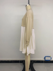 Detail view of camel sweatshirt upper and white pleated hem on a casual layered dress