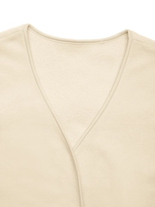 Close-up of beige fleece vest featuring V-neckline with precision stitching details