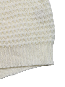 Detail van gebreid vest in crème met honingraatstructuur en geribbelde zoomafwerking