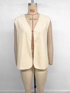 Detail of a creamy white fleece vest with a minimalist V-neck and soft textured fabric