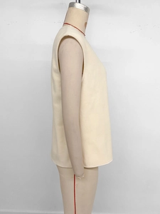 Detail of soft cream polar fleece vest showing thick texture and minimalist round neck design