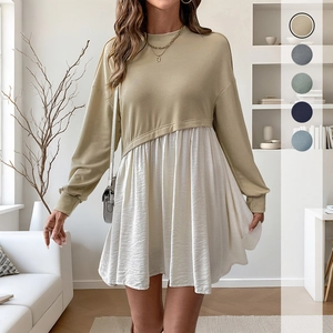 Long-sleeved patchwork dress with khaki knit top and white pleated skirt in a cozy home setting