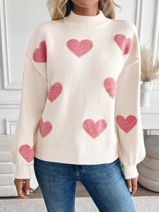 Details der Strickstruktur des cremefarbenen Pullovers mit rosa Jacquard-Herzen und Rollkragen