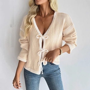 Beige V-neck knitted cardigan with white bow ties and contrasting trim detailing