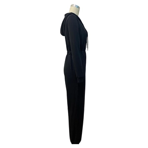 Side view of black hooded jumpsuit featuring elastic waist and ribbed ankle cuffs