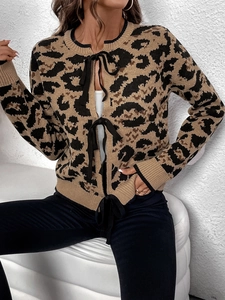 Dettaglio del cardigan leopardato con eleganti chiusure a nastro nero e trama in maglia