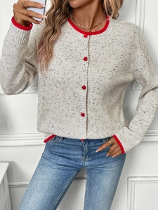 Close-up of color-block knit cardigan with red heart buttons and ribbed cuffs