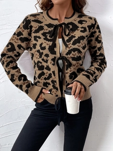 Dettaglio del cardigan in maglia leopardata con eleganti fiocchi in nastro nero lucido