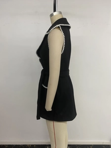 Détail du gilet sans manches noir avec bordure en dentelle blanche et ceinture nouée