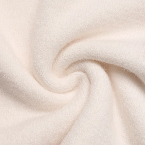 Makroaufnahme der weichen, cremeweißen Stricktextur des Herz-Pullovers für Damen