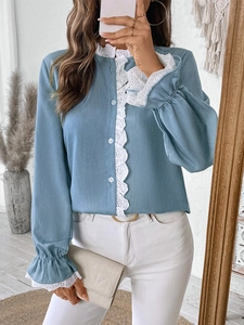 Close-up of long-sleeve light blue shirt with white lace patchwork and ruffled cuffs