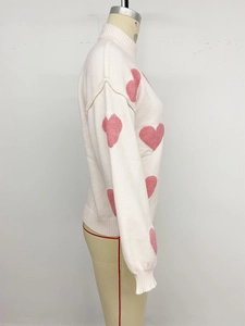 Detailansicht des Herz-Jacquard-Strickpullovers mit Rippbündchen auf einer Schneiderpuppe