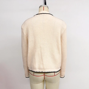 Vue de dos d'un gilet en maille crème avec bordure festonnée noire et maille côtelée