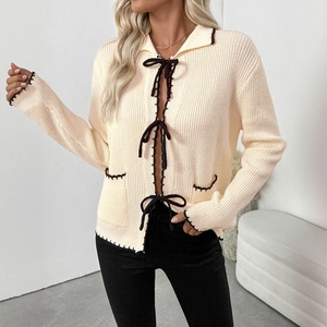Gilet en maille crème avec nœuds sombres et bordures contrastées pour un look hivernal