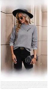 Detail of grey knit sweatshirt with asymmetric button collar and diamond texture pattern