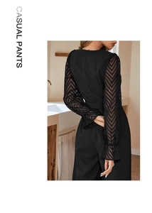 Close-up of elegant black jumpsuit featuring sheer chevron lace sleeves and back zipper