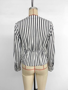 Back view of classic black and white vertical striped shirt with waist pleats and button cuffs