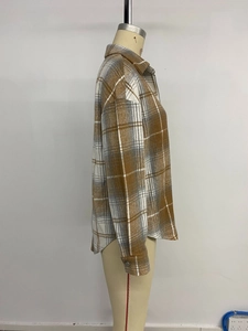 Detail of loose-fit plaid shirt with drop shoulders and curved hem in brown flannel
