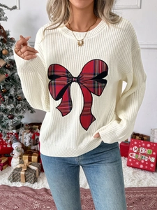 Detail of white knit sweater with a large red plaid bow applique for Christmas style