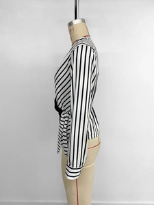 Side view detail of V-neck striped blouse featuring waist tie and elegant cuff buttons