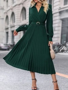 Détail de la robe plissée vert foncé avec col en V élégant et boucle de ceinture dorée