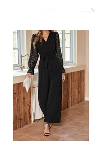 Detail of elegant black jumpsuit featuring sheer mesh bell sleeves and a deep V-neckline