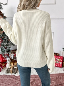 Back view of cream knit sweater with ribbed texture in festive Christmas setting