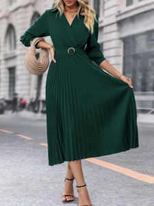 Détail de la robe plissée vert foncé avec col en V et ceinture à boucle ronde élégante