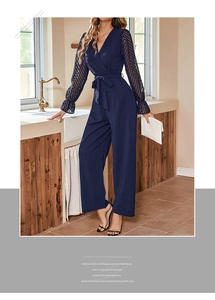 Detail of navy jumpsuit with sheer mesh lantern sleeves and delicate ruffled cuffs
