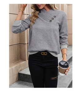 Detail of light grey sweater featuring diamond textured knit and criss-cross buttoned collar