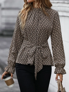 Detail of long sleeve blouse with chain geometric print, tie waist, and ruffled cuffs