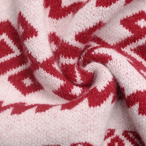 Macro shot of soft knit fabric featuring red and pink floral jacquard patterns