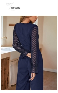 Detail of navy blue jumpsuit featuring sheer chevron mesh sleeves and ruffled cuffs