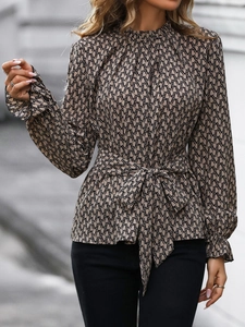 Detail of belt waist tie and chain print pattern on women's long sleeve blouse