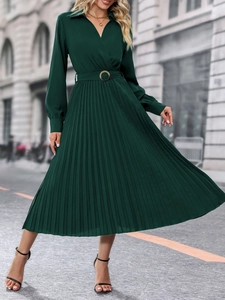 Détail de robe midi plissée vert foncé avec col en V croisé et ceinture dorée