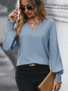 Detail of sky blue pleated lantern sleeves and elastic cuffs on a stylish V-neck blouse