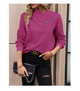 Detail of fuchsia long sleeve knit top with asymmetric V-neck and decorative metal buttons