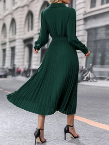 Vue latérale dynamique d'une robe maxi plissée vert foncé avec ceinture fluide